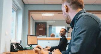 Two recruitment consultants in front of the computer smiling