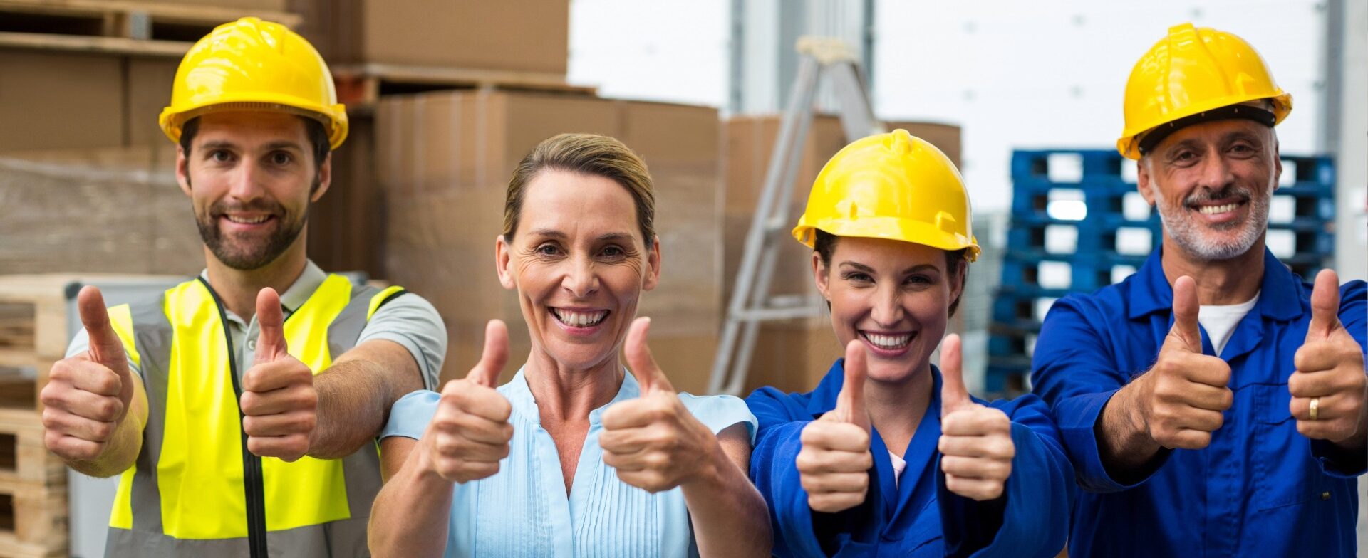 Group of smiling construction workers showing thumbs up
